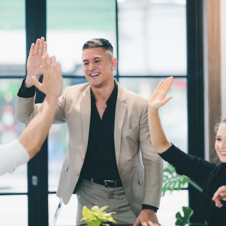 success and winning concept - happy business team celebrating victory in coworking space